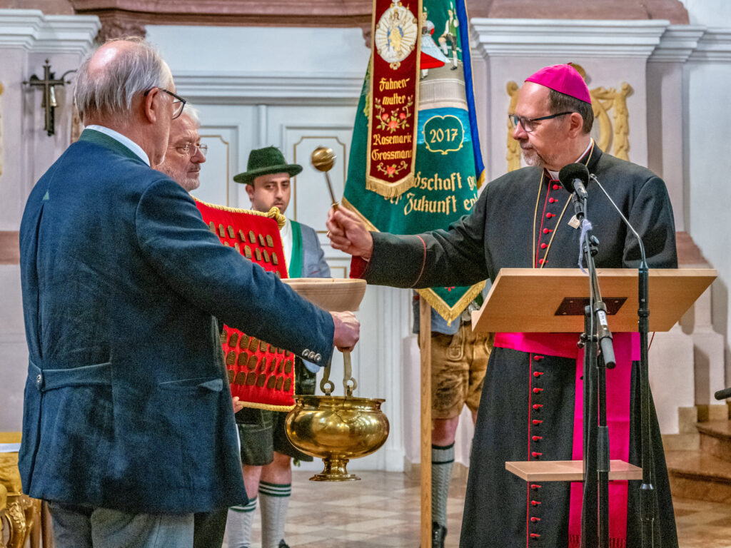 in besonderer Moment der Feierstunde: Weihbischof Wolfgang Bischof segnete die Erinnerungsanstecker, die an die Mitwirkenden aus Chor und Orchester sowie an Weggefährten Hans Bergers überreicht wurden.
