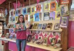 Büchereileiterin Melanie Schieber präsentiert die Ausstellung „Mein Lieblingsbuch & Ich“; 27 Leserinnen und Leser haben ihre Lieblingsbücher kreativ in Szene gesetzt.