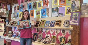 Büchereileiterin Melanie Schieber präsentiert die Ausstellung „Mein Lieblingsbuch & Ich“; 27 Leserinnen und Leser haben ihre Lieblingsbücher kreativ in Szene gesetzt.
