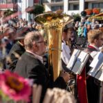 Blasmusiker spielen, das Publikum lauscht beim Erntedankfest auf dem Kurplatz.