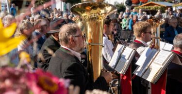 Blasmusiker spielen, das Publikum lauscht beim Erntedankfest auf dem Kurplatz.