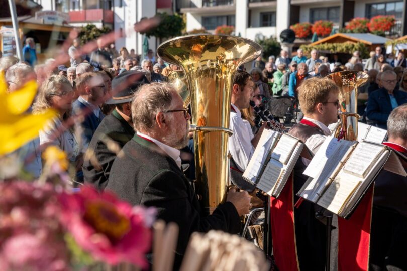Blasmusiker spielen, das Publikum lauscht beim Erntedankfest auf dem Kurplatz.