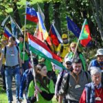 Teilnehmende des Festumzugs mit Flaggen während des gemeinsamen Weges.