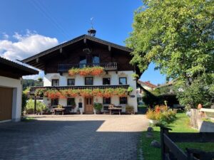 Vorderansicht des Bachschneiderhauses mit blumengeschmücktem Balkon