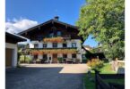 Vorderansicht des Bachschneiderhauses mit blumengeschmücktem Balkon