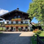 Vorderansicht des Bachschneiderhauses mit blumengeschmücktem Balkon