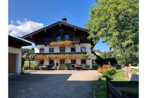 Vorderansicht des Bachschneiderhauses mit blumengeschmücktem Balkon