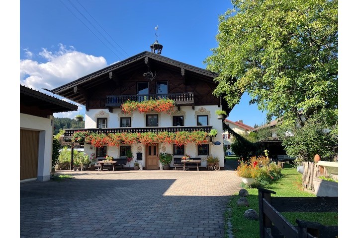Vorderansicht des Bachschneiderhauses mit blumengeschmücktem Balkon