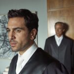 Szene aus 'Der Fall Collini' mit einem jungen Anwalt im Vordergrund.
