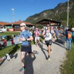 Läuferinnen und Läufer beim Auftakt des Rennens vor Bergkulisse.