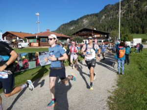 Läuferinnen und Läufer beim Auftakt des Rennens vor Bergkulisse.