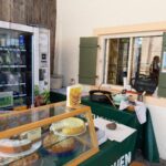 Regio-Box und Auslage mit hausgemachten Kuchen am Verkaufsfenster des Bergbauernladens.