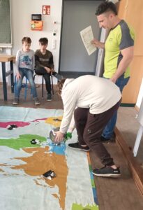 Teile von Handys werden auf einer Weltkarte nach Herkunftsregionen sortiert.