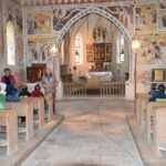 Hartmut Rihl erklärt den an die Wand gemalten Heiligen Christophorus