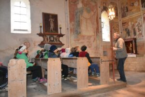 Hartmut Rihl erklärt den an die Wand gemalten Heiligen Christophorus