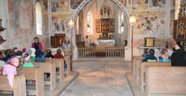 Hartmut Rihl erklärt den an die Wand gemalten Heiligen Christophorus