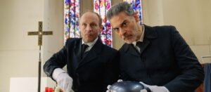 Szenenbild aus 'Zweigstelle' mit zwei Protagonisten in einer Kirche.