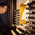 Ein Organist bei der Vorbereitung und beim Spiel an der Orgel.