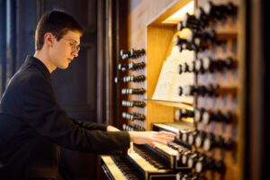Ein Organist bei der Vorbereitung und beim Spiel an der Orgel.