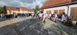 Kirwaburschen und Kirwamadla tanzen vor der voll besetzten Kulisse des Dorfplatzes.