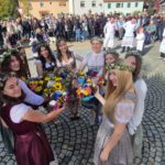 Kirwamadla stoßen mit geschmückten Krügen an.