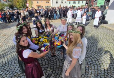 Kirwamadla stoßen mit geschmückten Krügen an.