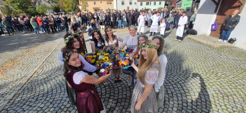 Kirwamadla stoßen mit geschmückten Krügen an.
