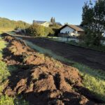 Erdarbeiten am Kalkgraben für den Hochwasserschutz neben Wohnhäusern.