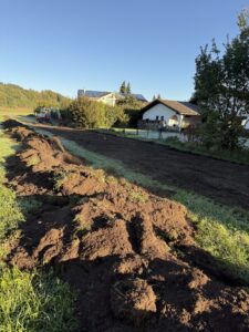 Erdarbeiten am Kalkgraben für den Hochwasserschutz neben Wohnhäusern.