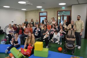 23 Neugeborene mit ihren Eltern bei der Begrüßung im Haus der Familie.