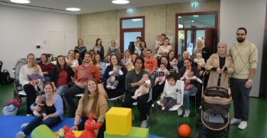 23 Neugeborene mit ihren Eltern bei der Begrüßung im Haus der Familie.