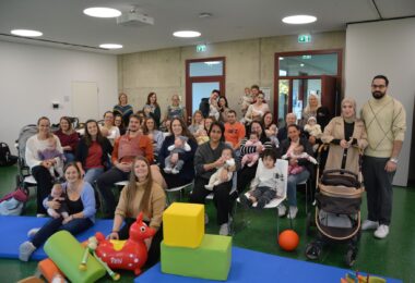 23 Neugeborene mit ihren Eltern bei der Begrüßung im Haus der Familie.