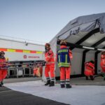 Johanniter richten einen Einsatzbereich mit Zelt und Material ein.