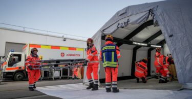 Johanniter richten einen Einsatzbereich mit Zelt und Material ein.