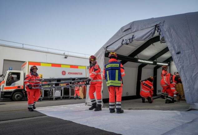 Johanniter richten einen Einsatzbereich mit Zelt und Material ein.