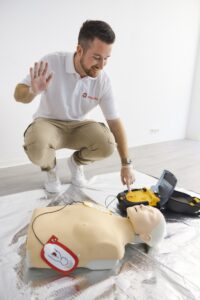 Defibrillator und Elektroden neben einer Reanimationspuppe