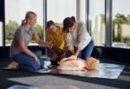 Johanniter zeigen und üben die Herzdruckmassage in einem Erste‑Hilfe‑Kurs