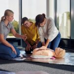 Johanniter zeigen und üben die Herzdruckmassage in einem Erste‑Hilfe‑Kurs