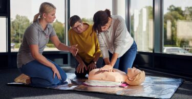 Johanniter zeigen und üben die Herzdruckmassage in einem Erste‑Hilfe‑Kurs