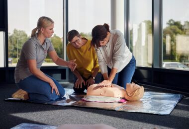 Johanniter zeigen und üben die Herzdruckmassage in einem Erste‑Hilfe‑Kurs
