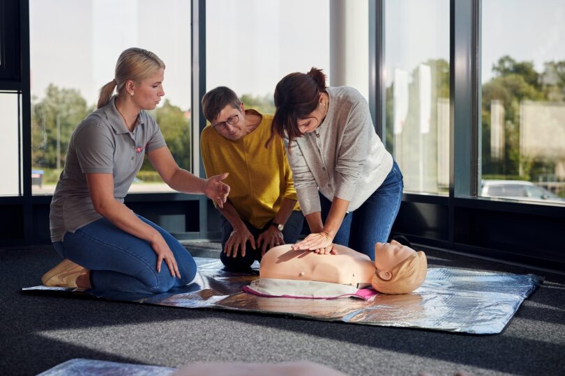 Johanniter zeigen und üben die Herzdruckmassage in einem Erste‑Hilfe‑Kurs