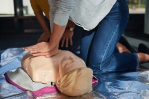 Nahaufnahme einer Herzdruckmassage an einer Reanimationspuppe