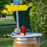 Startpunkt des Alpina Antica Trail: Weinfasstisch mit Wegweiser.