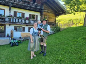 Michi und Pia Astl mit ihrem Kind vor dem Hof.