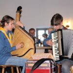 Jugendliche spielen Saiteninstrument und Akkordeon beim Hoagascht.