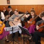Eine Jugendgruppe begleitet das Hoagascht mit Gitarren.