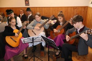Eine Jugendgruppe begleitet das Hoagascht mit Gitarren.