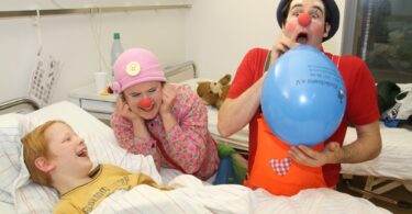 Bremer Klinikclowns unterhalten ein Kind im Krankenhaus.