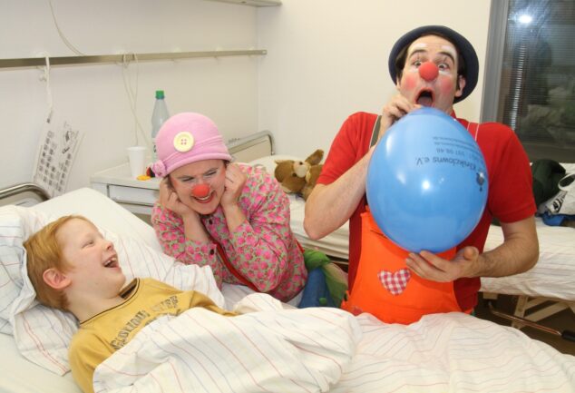 Bremer Klinikclowns unterhalten ein Kind im Krankenhaus.