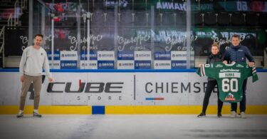 Vertreter des CUBE Store Chiemsee und der Starbulls präsentieren ein Trikot von Shane Hanna in der SPIE Arena.